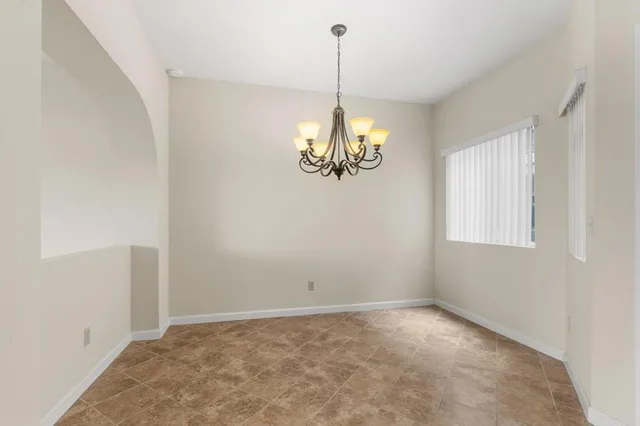 a view of a room with a chandelier fan and windows