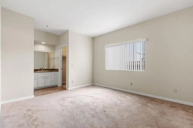 a view of empty room with a kitchen