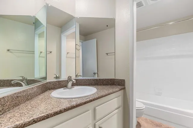a bathroom with a granite countertop sink and a mirror