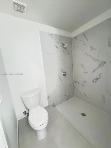 a bathroom with a toilet and shower