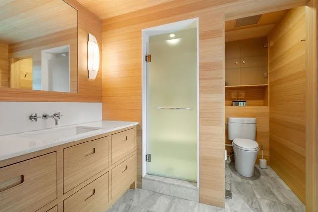 a bathroom with a granite countertop sink toilet and shower