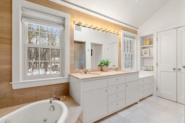 a spacious bathroom with a double vanity sink mirror and bathtub