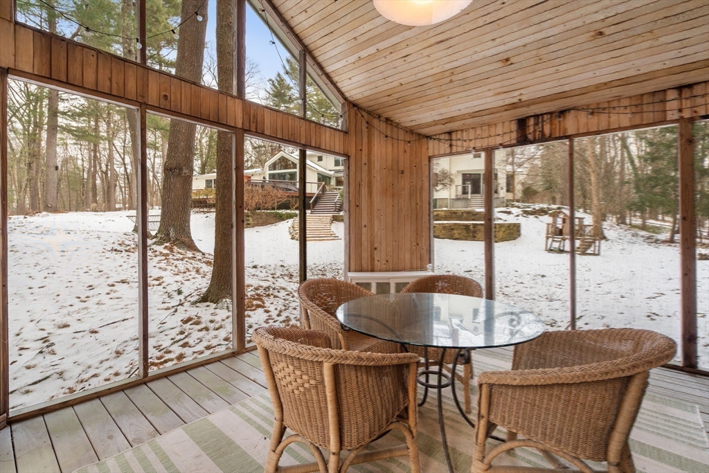 56 Isaac Davis Road Concord, MA 01742 - Photo 35 of 42 a dining room with furniture wooden floor and a chandelier