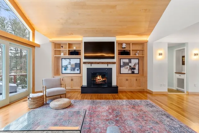a living room with furniture a flat screen tv and a fireplace