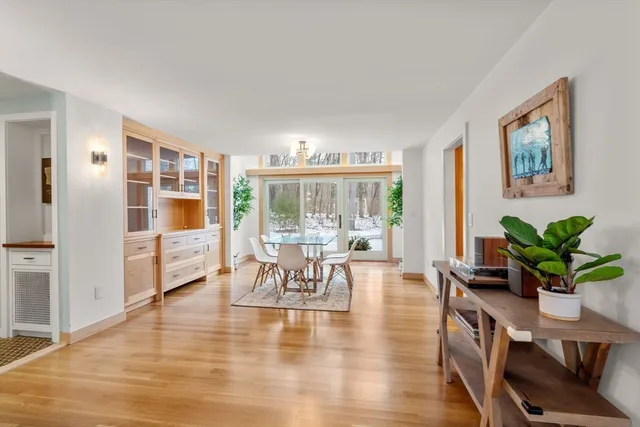 a dining room with furniture potted plants and wooden floor