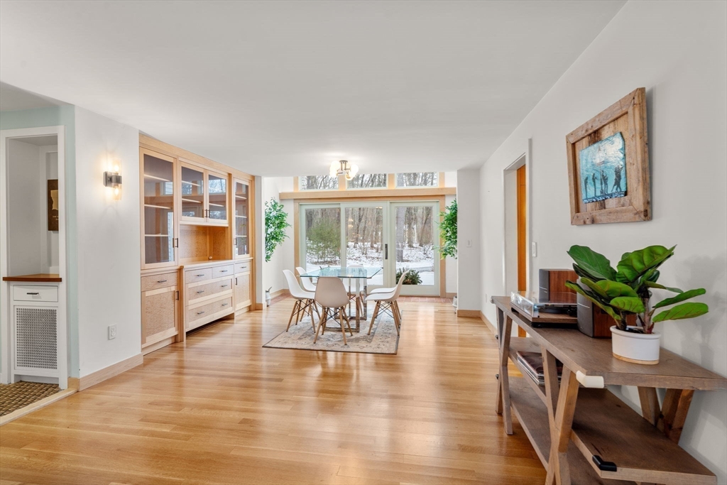 56 Isaac Davis Road Concord, MA 01742 - Photo 5 of 42 a dining room with furniture potted plants and wooden floor