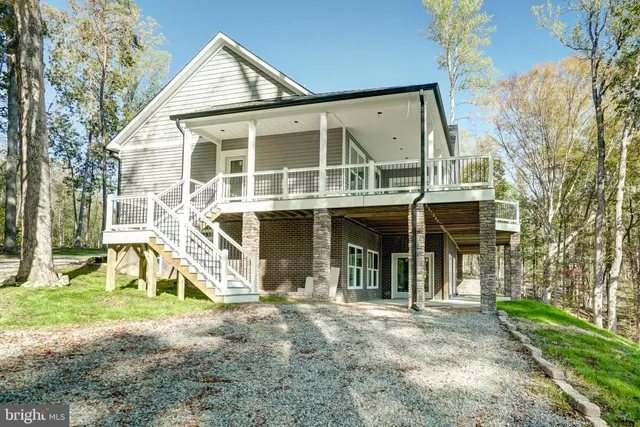 a view of a house with large windows and a small yard