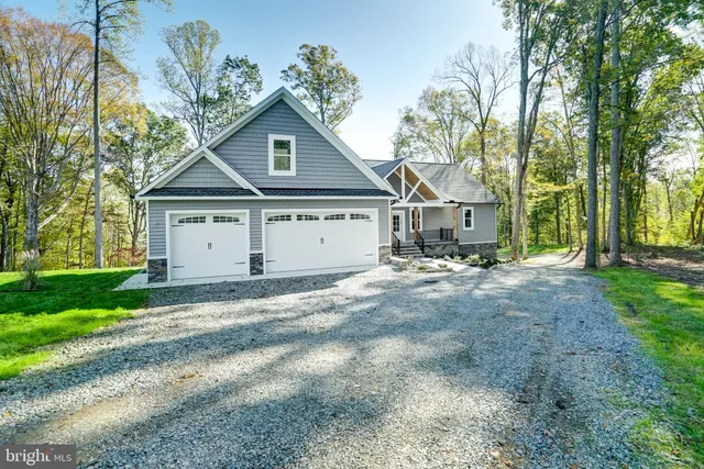 a view of a house with a yard and large trees
