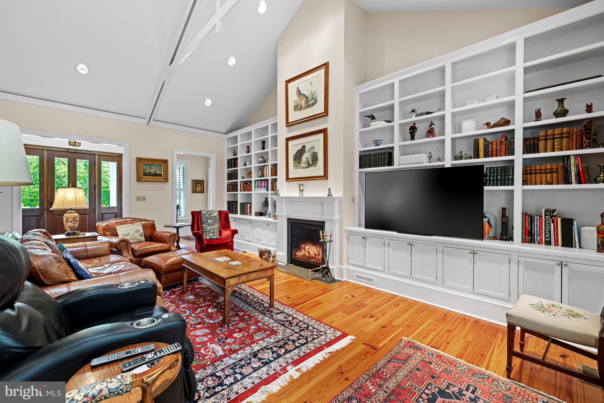 20147 Woodtrail Road Round Hill, VA 20141 - Photo 7 of 41 a living room with furniture a flat screen tv and a bookshelf