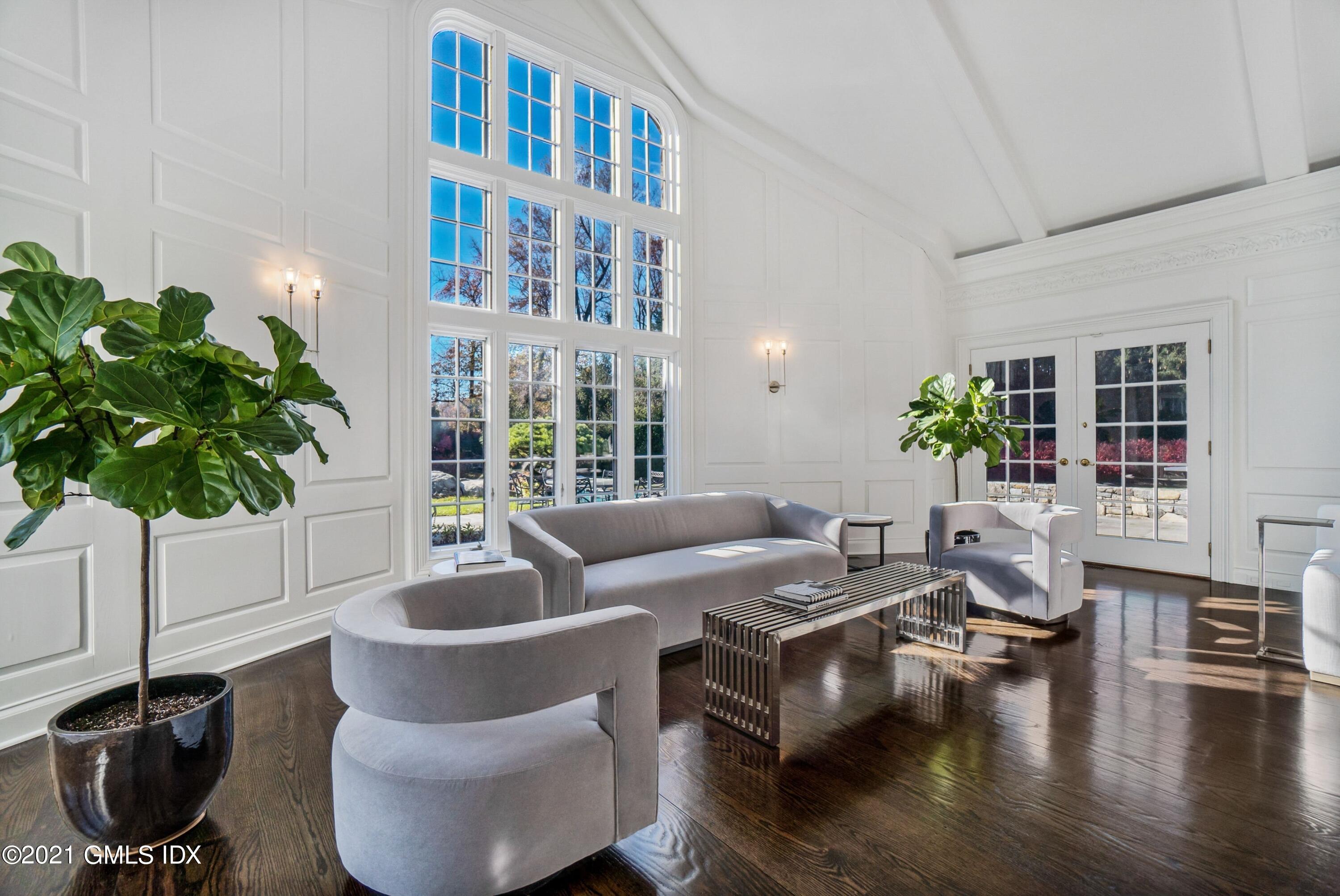 60 Round Hill Road Greenwich, CT 06831 - Photo 13 of 34 a living room with furniture a bookshelf and a potted plant