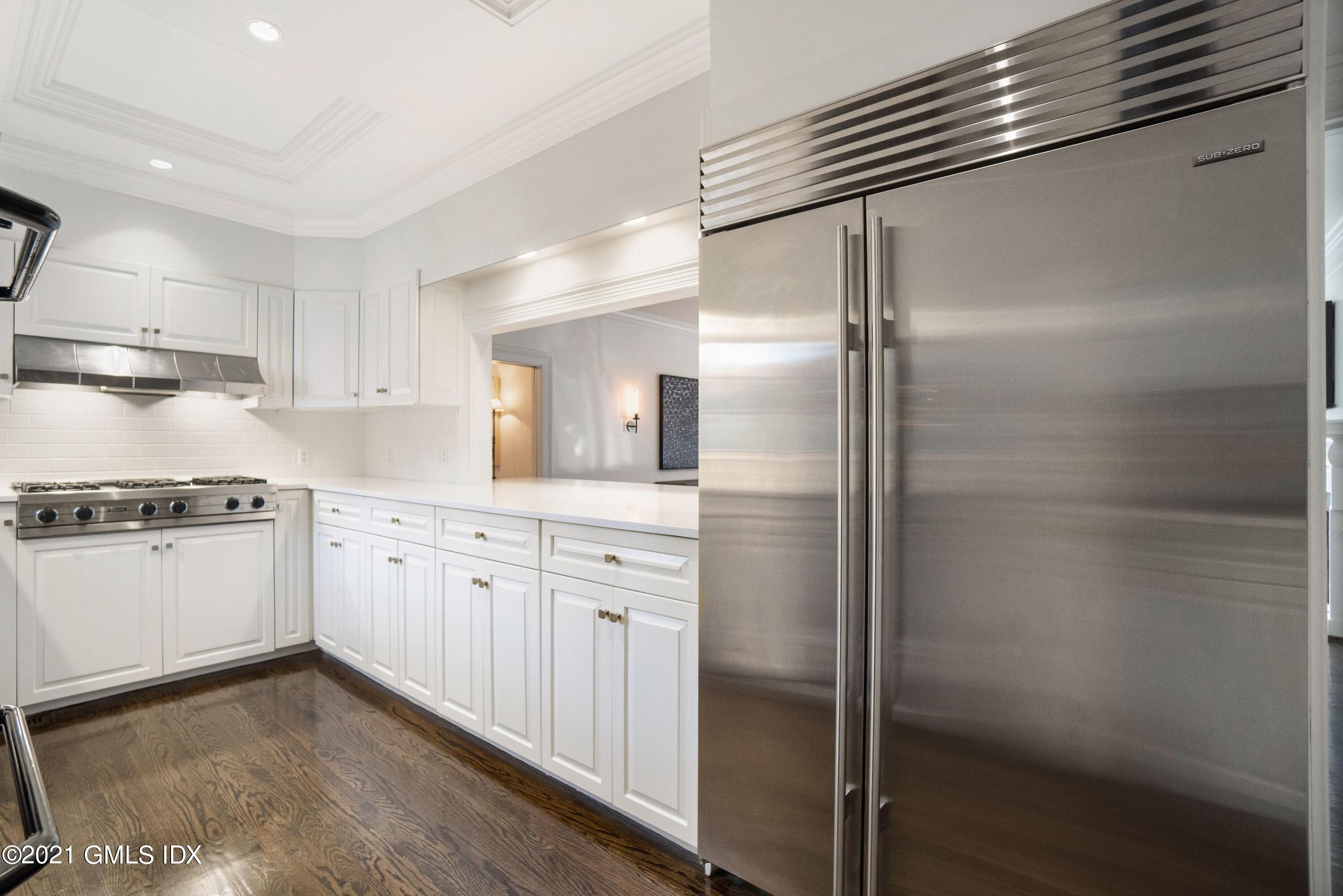 60 Round Hill Road Greenwich, CT 06831 - Photo 20 of 34 a kitchen with granite countertop a refrigerator and white cabinets