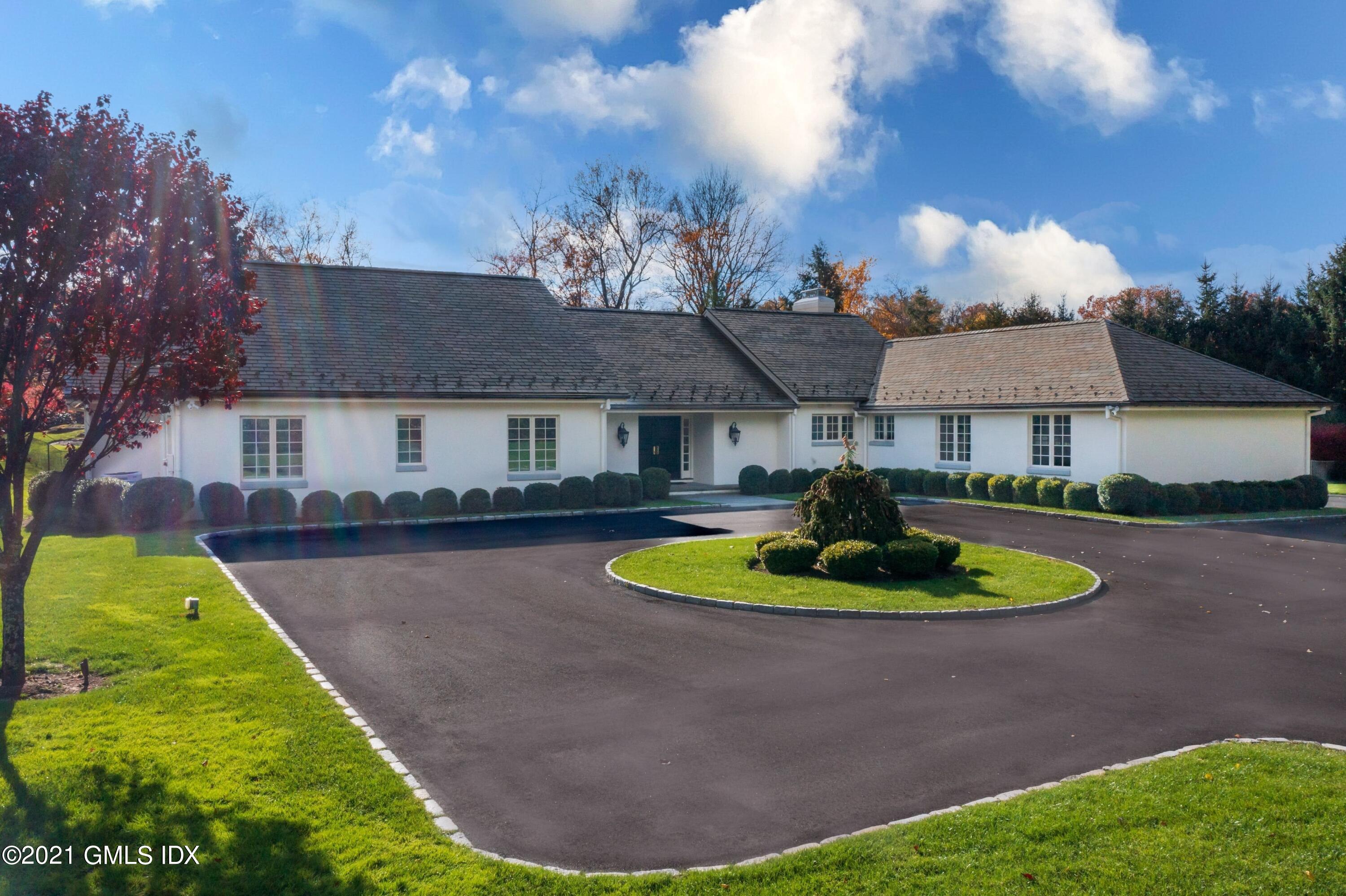 60 Round Hill Road Greenwich, CT 06831 - Photo 2 of 34 a front view of a house with a yard and trees