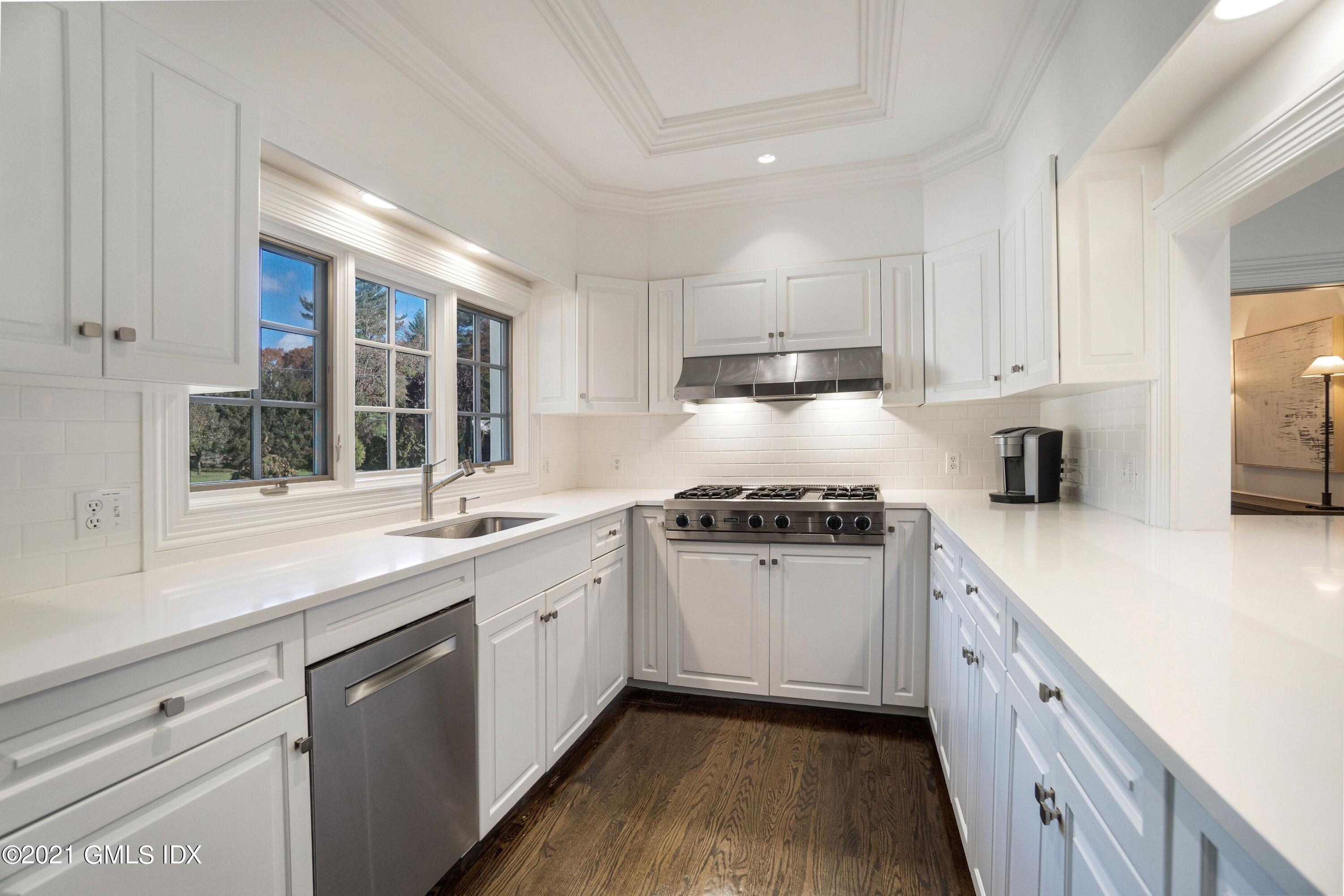 60 Round Hill Road Greenwich, CT 06831 - Photo 21 of 34 a kitchen with granite countertop white cabinets white appliances a sink and a window