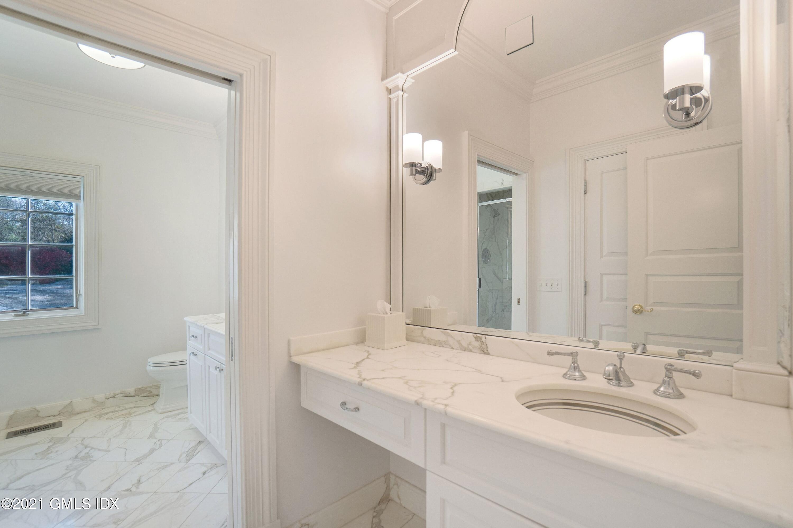 60 Round Hill Road Greenwich, CT 06831 - Photo 25 of 34 a bathroom with a granite countertop sink and a mirror