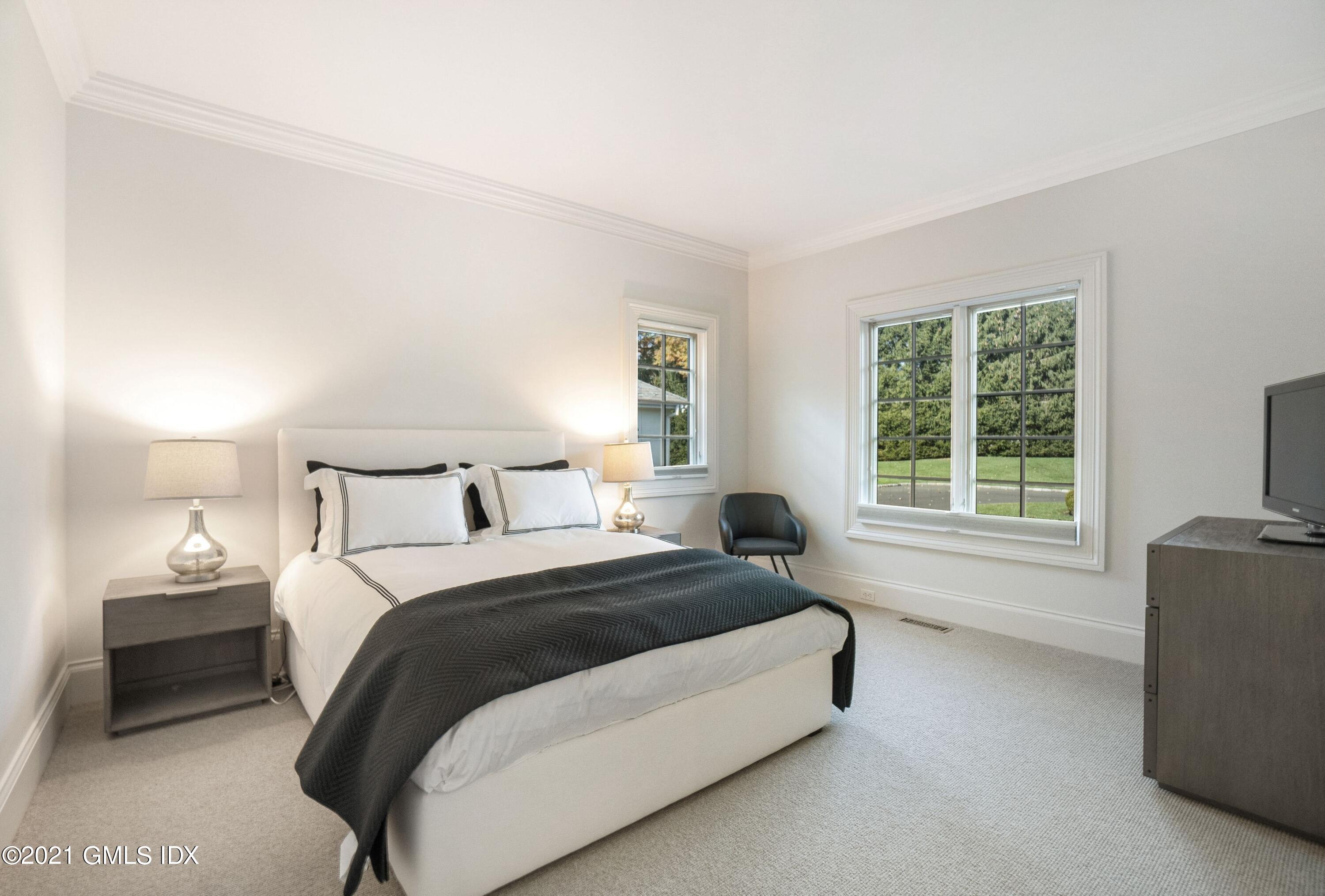 60 Round Hill Road Greenwich, CT 06831 - Photo 27 of 34 a spacious bedroom with a bed and a window