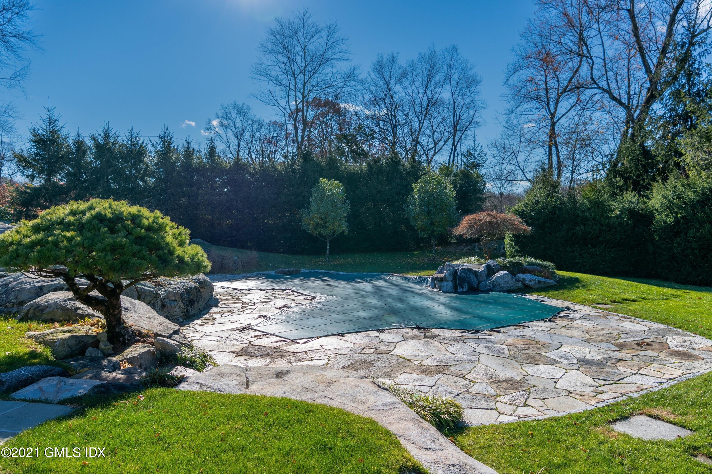 60 Round Hill Road Greenwich, CT 06831 - Photo 10 of 34 a view of a backyard with plants and a fountain
