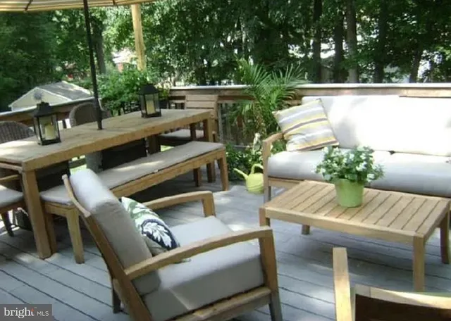 a view of a patio with couches chairs under an umbrella with a small yard