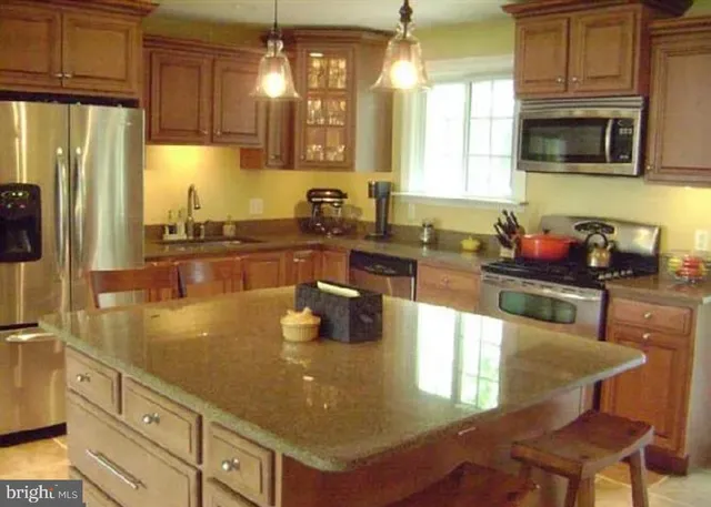 a kitchen with stainless steel appliances granite countertop a sink refrigerator and cabinets
