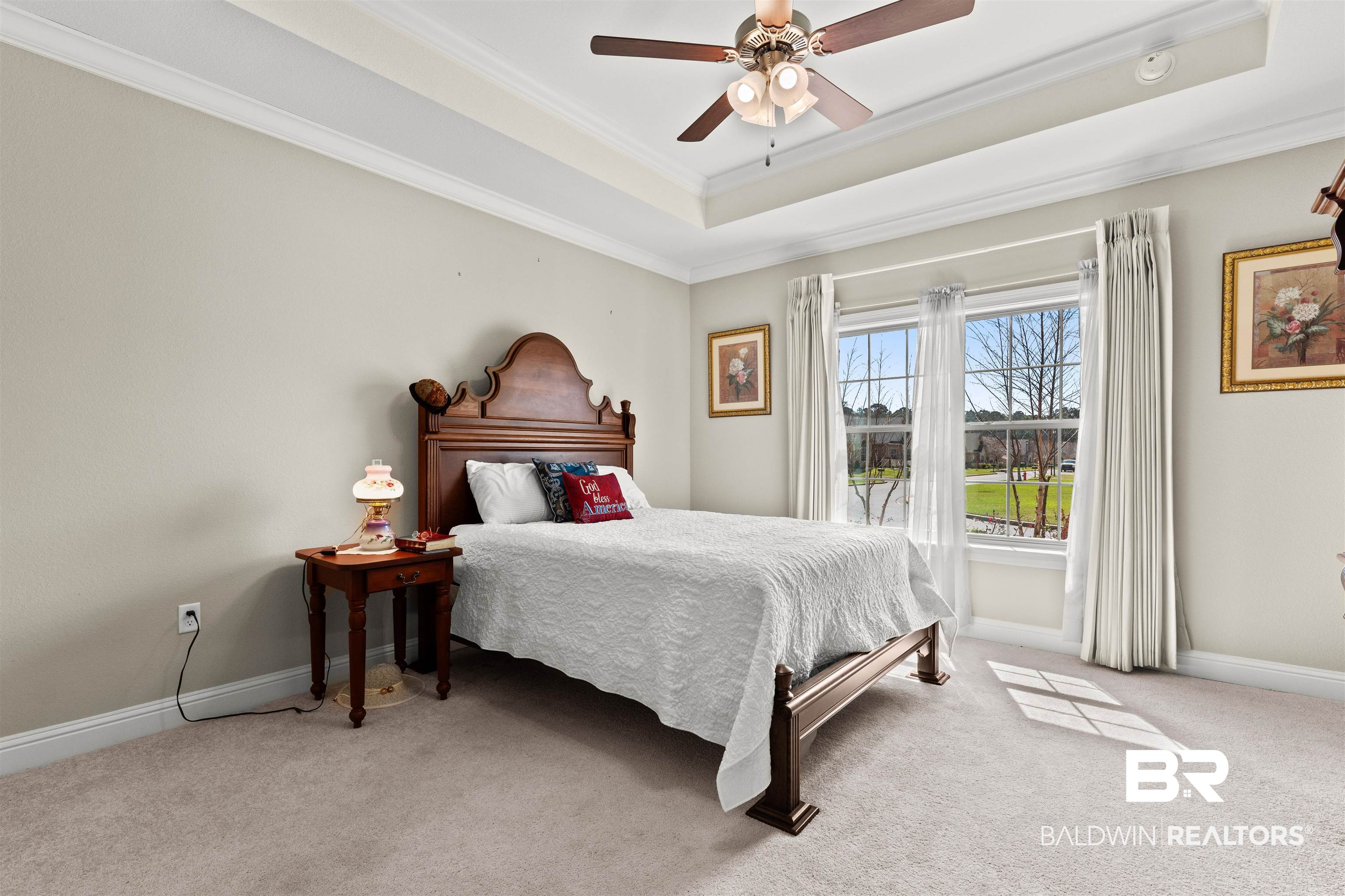 301 Holmes Avenue, Unit 301 Foley, AL 36535 - Photo 20 of 54 Bedroom with crown molding, ceiling fan, baseboards, light carpet, and a raised ceiling