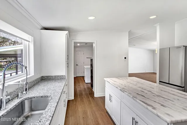a kitchen with granite countertop a sink and a refrigerator