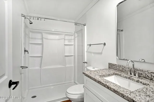 a view of a room with wooden floor and a ceiling fan