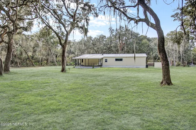 a view of a field with trees in the background