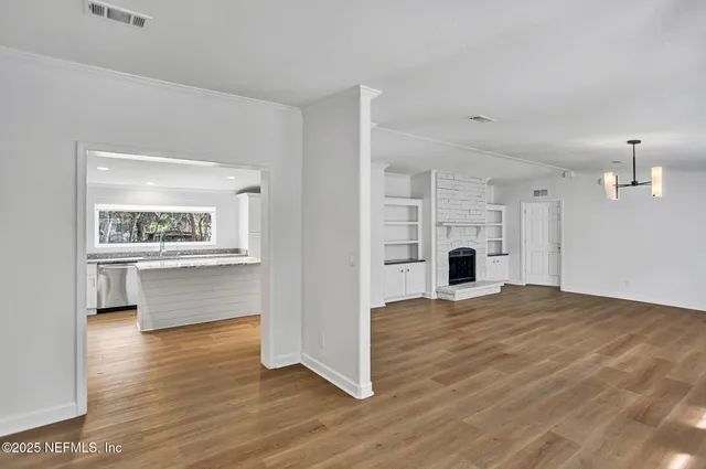 a view of an empty room with a window and a fireplace