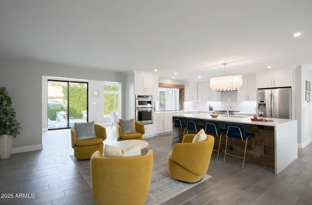 a living room with furniture kitchen view and a large window