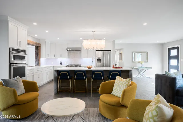 a living room with furniture kitchen view and a window