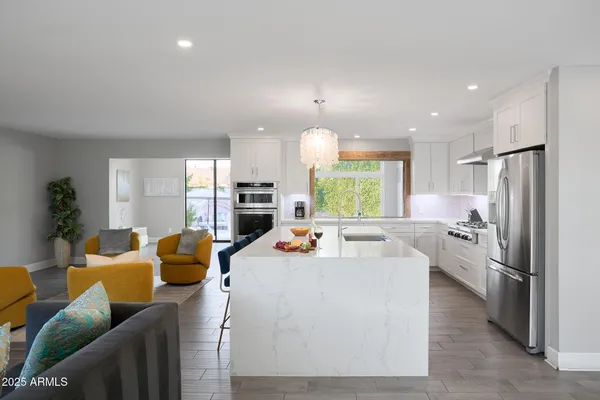 a kitchen with stainless steel appliances refrigerator dining table and chairs