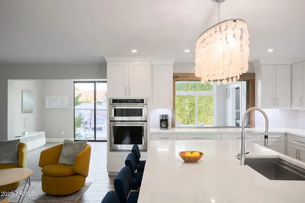 a kitchen with stainless steel appliances granite countertop a sink and a large window
