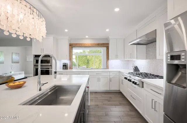 a kitchen with a sink a stove and cabinets