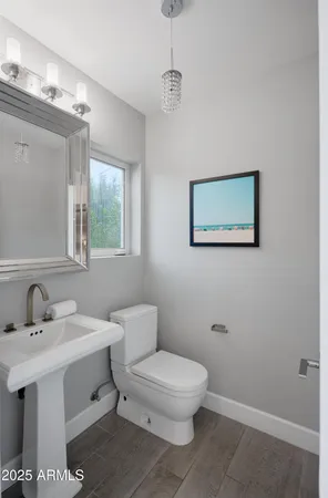 a bathroom with a toilet a sink and mirror