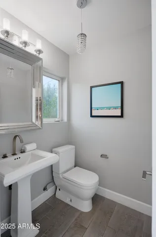 a bathroom with a toilet a sink and mirror