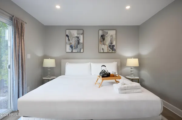 a bedroom with a bed and painting on the wall