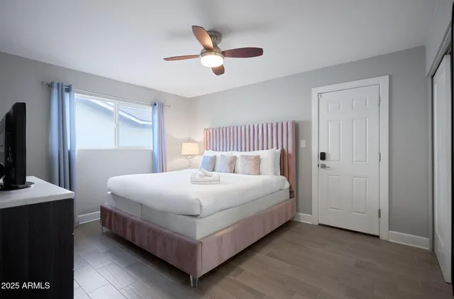 a bedroom with a bed and a flat tv screen on dresser