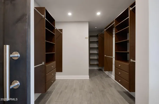 a view of walk in closet with wooden floor and closet