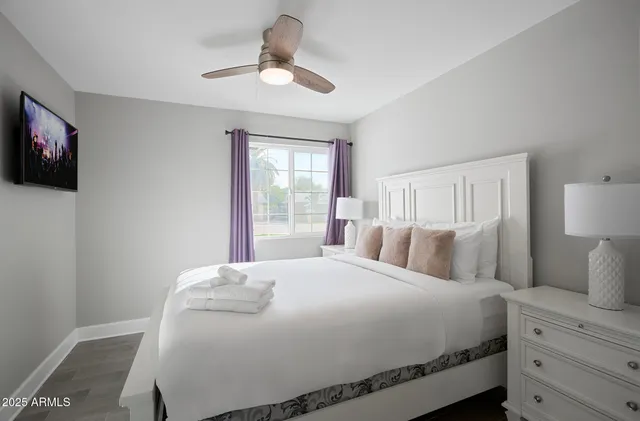 a bedroom with a large bed and a flat screen tv