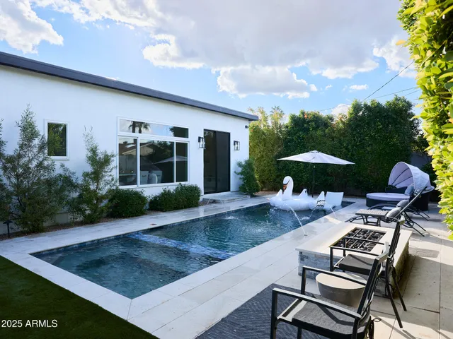 a view of a patio with a table and chairs under an umbrella