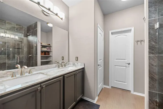 a bathroom with a granite countertop sink a large mirror and a shower