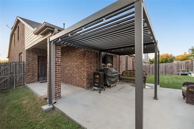 a backyard of a house with barbeque oven table and chairs