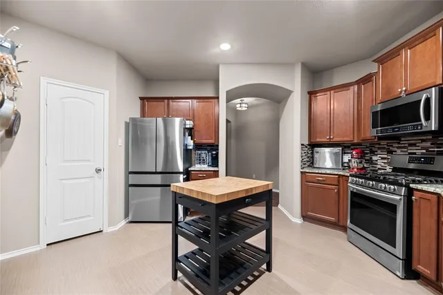 a kitchen with stainless steel appliances a refrigerator a stove a sink and a refrigerator