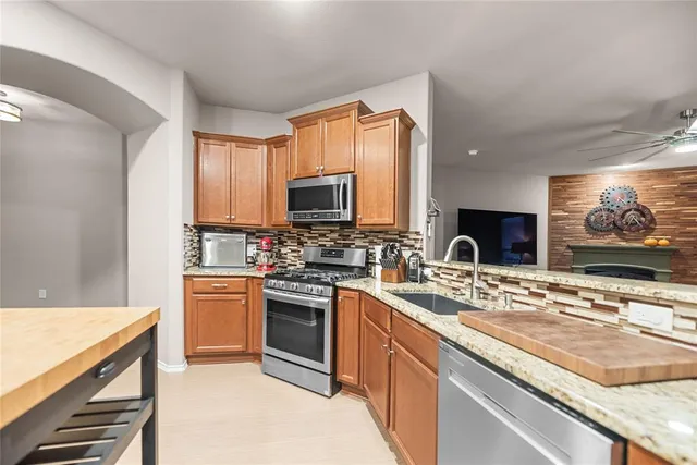 a kitchen with stainless steel appliances granite countertop a sink stove and microwave