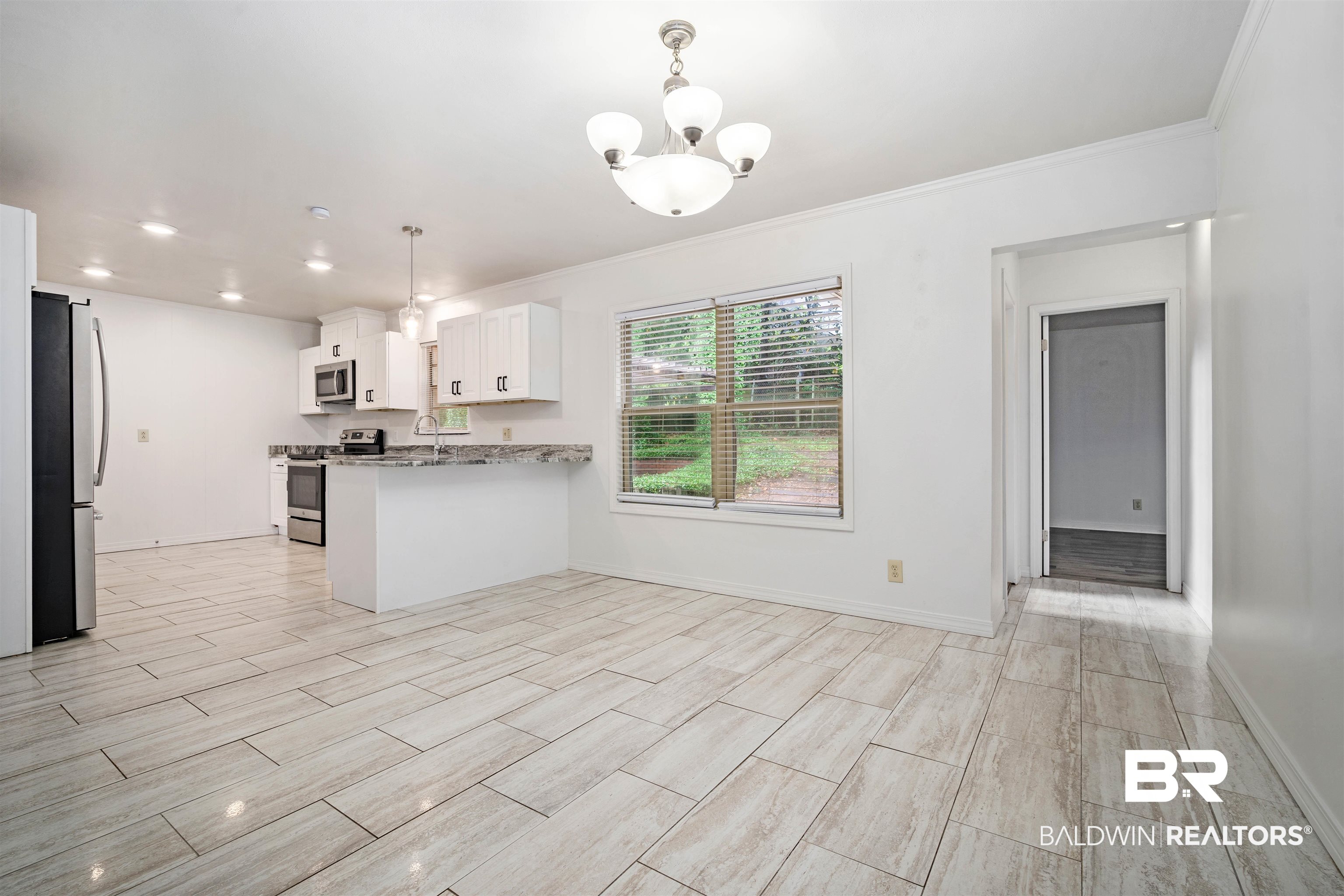 570 Markham Drive Mobile, AL 36609 - Photo 9 of 25 Kitchen with a peninsula, wood finish floors, white cabinetry, and stainless steel appliances