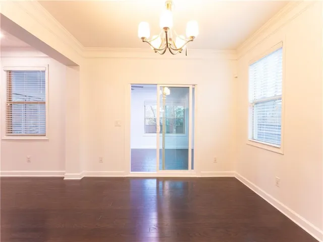 a view of an empty room with a kitchen chandelier fan and a kitchen view