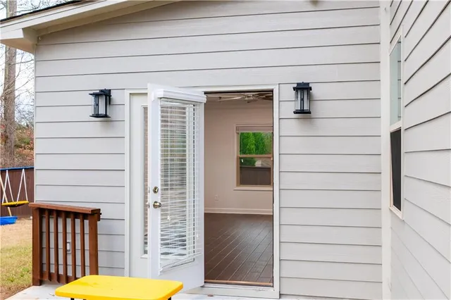 a view of a deck with two chairs and wooden fence