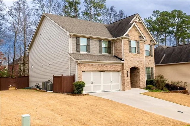 a view of a white house with a yard and garage