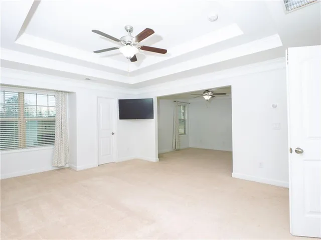an empty room with a window and a fan