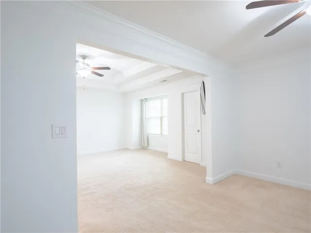 an empty room with a ceiling fan and a window