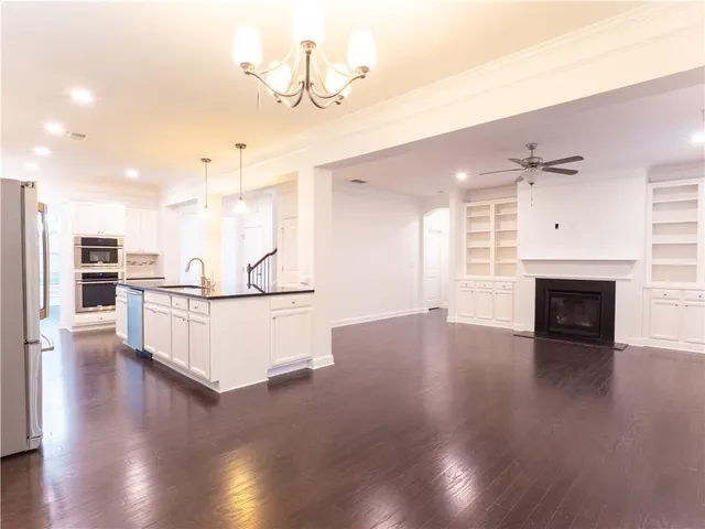 a kitchen with kitchen island granite countertop a sink cabinets stainless steel appliances and a counter top space